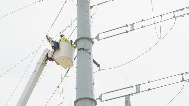 Electrical power linemen in bucket lift