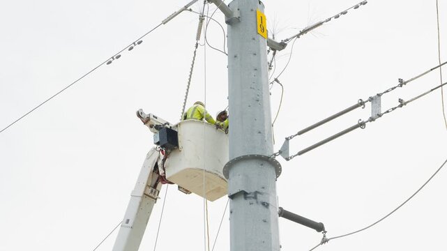 Electrical power linemen in bucket lift