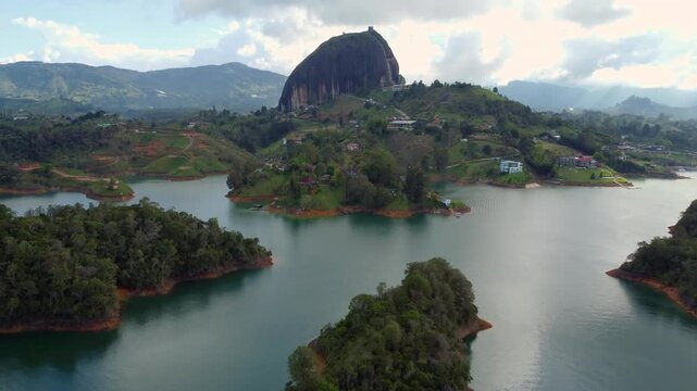 El Pe&ntilde;&oacute;n de Guatap&eacute; Wide Tilt Up Aerial from Lake-side on Cloudy Afternoon
