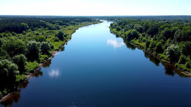 Aerial view of a wide, flowing river bordered by lush green forest
