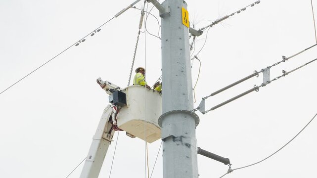 Electrical power linemen in bucket lift