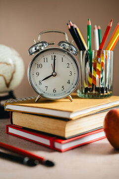 Academic planning with alarm clock on textbooks, study schedule concept