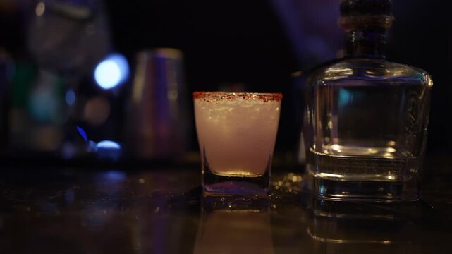 a cocktail at a bar served by a bartender