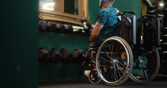 Man in wheelchair performing dumbbell bicep exercises in gym. Adaptive fitness, strength training, determination and active lifestyle concept.
