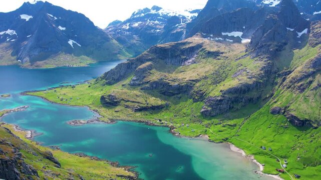 Aerial drone view of Lofoten Islands in Norway, featuring beautiful landscapes on Vindstad Beach near Reine, white sand clear water and dramatic mountains near the shore. Experience the natural beauty