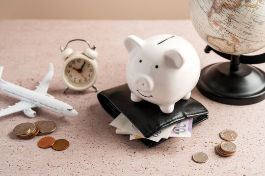 Travel savings planning with piggy bank, wallet, airplane, clock and globe, vacation budget finance concept