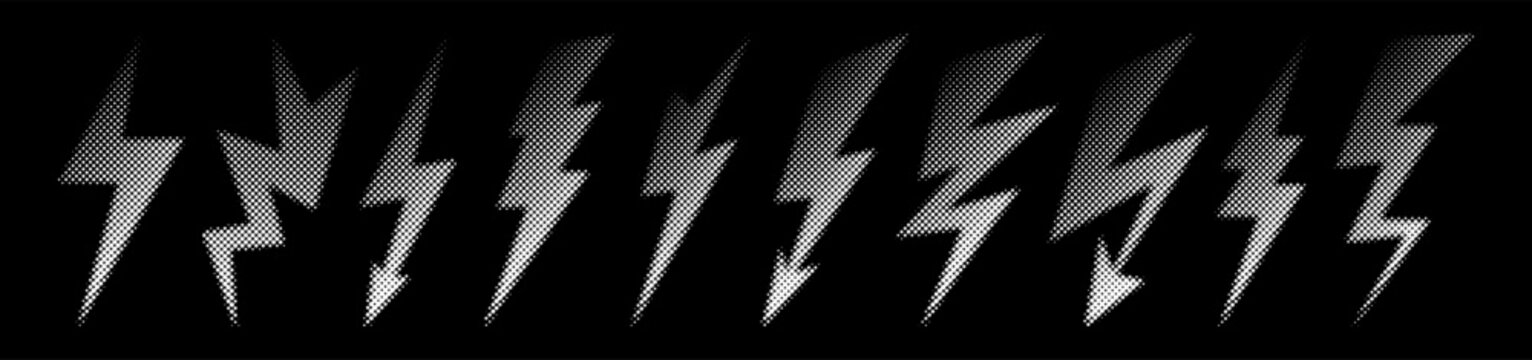 Halftone lightning bolt set with dotted shading and grainy texture. White thunder silhouettes on black background in graphic comic pop art style. Isolated vector elements.