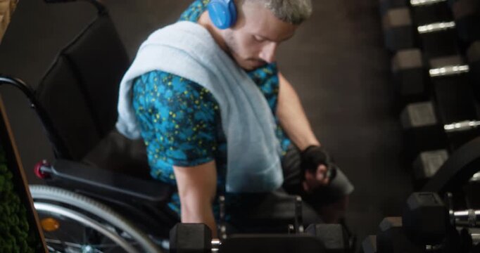 Man in wheelchair performing dumbbell bicep exercises in gym. Adaptive fitness, strength training, determination and active lifestyle concept.