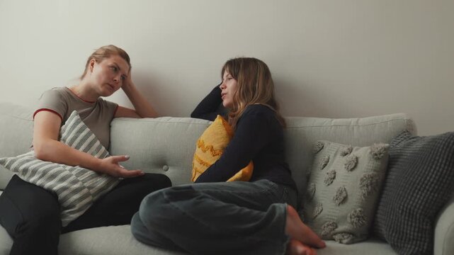 Mother and daughter having serious conversation on sofa