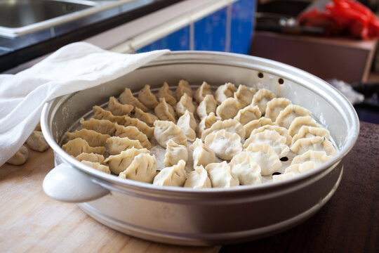 Raw handmade Chinese dumplings prepared on a plate, China