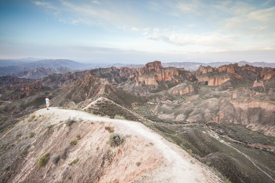 Man looking at the landscape at sunrise at the Danxia landform, Zhangye, Gansu, China