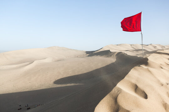 Chinese flag waving over crescent moon lake sand dunes, Dunhuang, Gansu, China