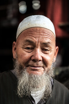 Portrait of aged uyghur man in traditional hat, Turpan, Xinjiang, China