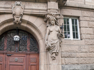 Obraz premium Close up of historical building facade detail with atlantes sculpture and stone wall in Poznan