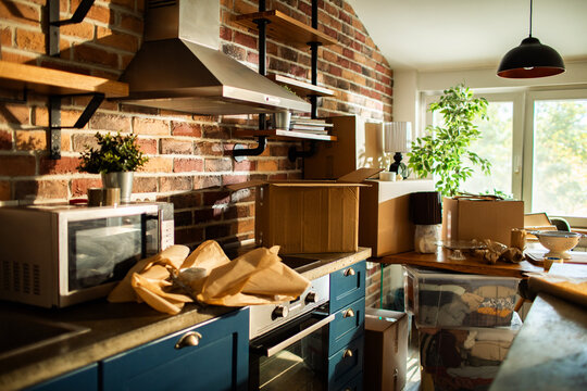 Home interior with moving boxes in sunlit brick kitchen