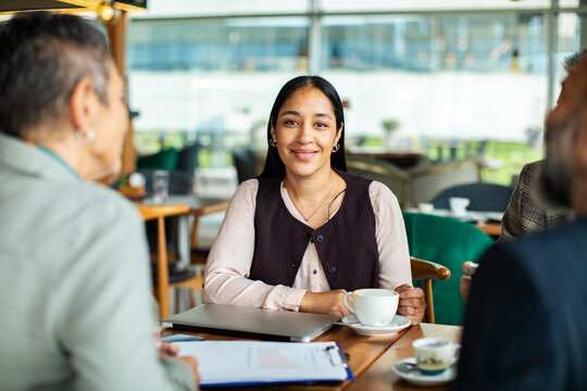 Smiling professional woman in business meeting at cafe