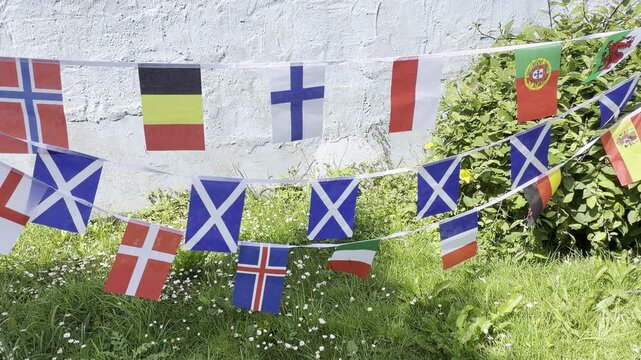 A vibrant display of international flags and decorative bunting fluttering in the breeze. Representing countries from around the world, this colourful scene celebrates unity, culture, diversity, and g