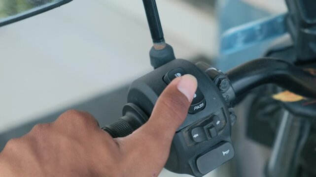Close-up of motorcycle handlebar switch operating headlight and pass light