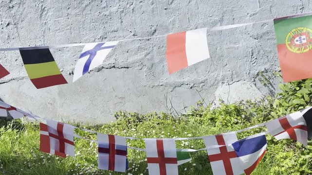 A vibrant display of international flags and decorative bunting fluttering in the breeze. Representing countries from around the world, this colourful scene celebrates unity, culture, diversity, and g