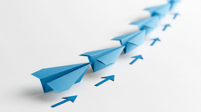 Leadership in Motion: A line of blue paper airplanes, each a symbol of aspiration and forward momentum, take flight in unison, guided by a path of directional arrows.