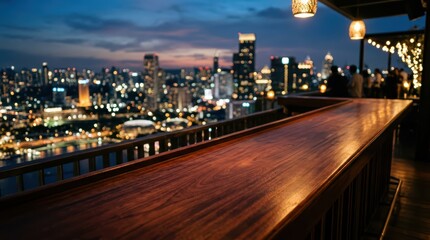 Fototapeta premium Rooftop bar counter with city skyline view at night. Empty wooden table overlooking urban landscape with glowing skyscraper lights. Luxury nightlife venue and terrace lounge concept.