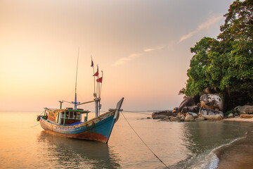 Traditional fishing boat anchored on serene tropical beach at sunset © ornax photo
