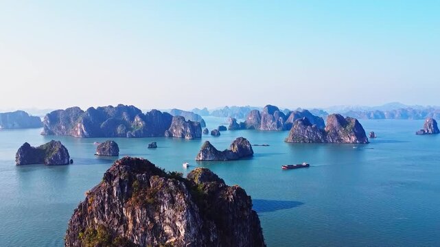 Stunning cinematic aerial drone view of Ha Long Bay, Vietnam, showcasing limestone karsts, emerald water, and scenic islands in a World Heritage site