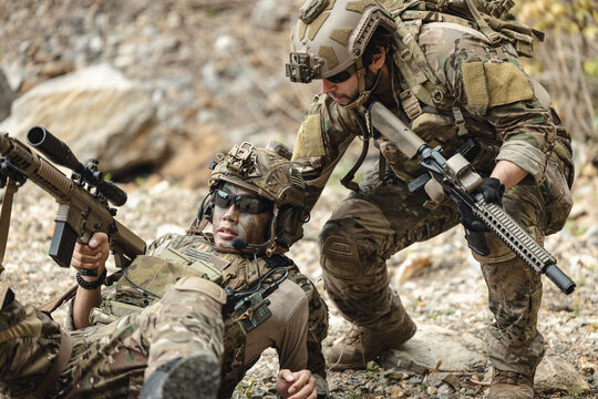 Marine Special Forces commando providing soldier injured evacuation assistance during military operation