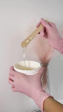 Depilator mixes sugar paste for sugaring, hair removal.