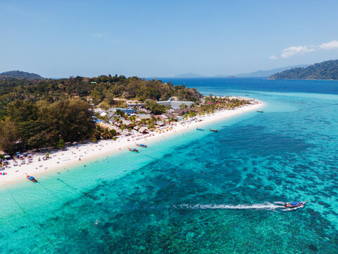 Aerial Drone View of Koh Lipe Island. Long tail Boat with tourists on the turquoise water.  Thailand