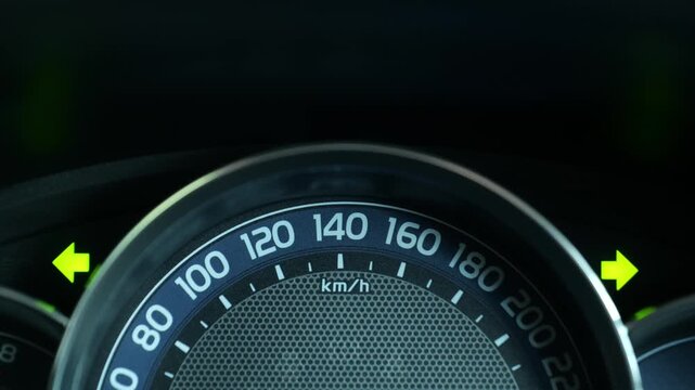 Car Dashboard Speedometer with Turn Signal Indicator Blinking, Close Up Interior View, Car Instrument Panel Showing Speed Gauge and Yellow Turn Signal Blinking Left and Right