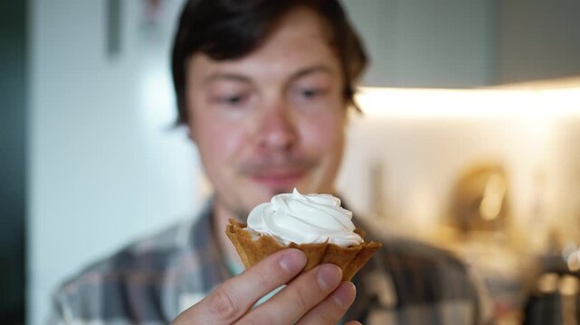 Caucasian man with a sweet tooth making funny faces while holding a cream tart, illustrating sugar addiction, compulsive overeating, and the potential risk of developing diabetes