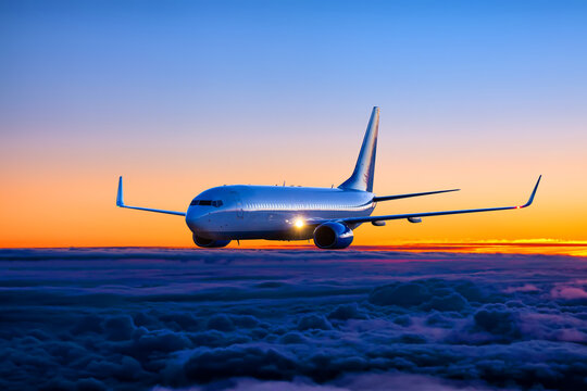 Passenger plane flies in the sunset sky