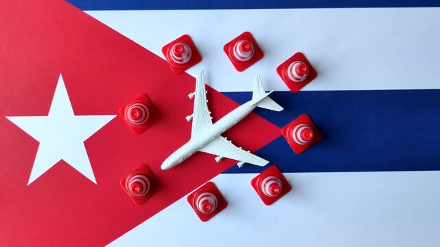 A mock up of airplane surrounded by no fly signs on a Cuba flag as a concept for a flight ban or cancellation