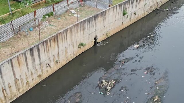 Drone View shows Drainage Water Flowing from Culvert Pipe into Urban Drainage Canal System
