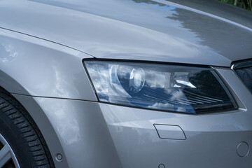 Switched-off xenon headlights on a car showcase modern automotive lighting technology, even when not in use, emphasizing sleek design and advanced equipment. Car dealership catalogs, automotive © Ann