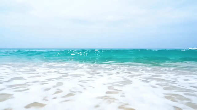 Ocean waves rolling onto sandy shore. Blue water moving. White foam crashing sand shore surf tide sea.