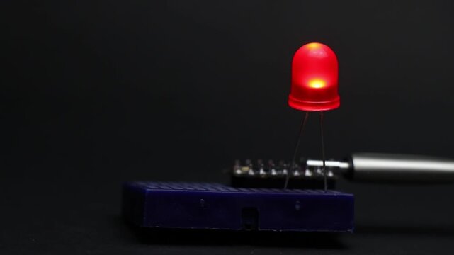 Blinking LED on breadboard controlled by a programmable microcontroller. Embedded systems prototype with LED blink pattern