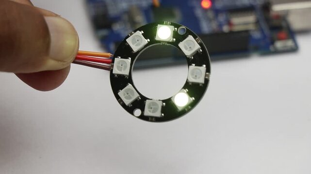 Programmable ARGB LED ring light glowing with color patterns controlled by the microcontroller on the background