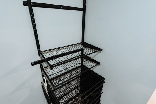 Empty metal storage cage with stacked wire shelves