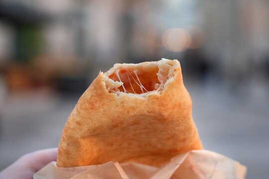 Panzerotti savory pastry, local street food in Bitonto, Italy. Panzerotto with tomato and mozzarella cheese. Smaller type of calzone.