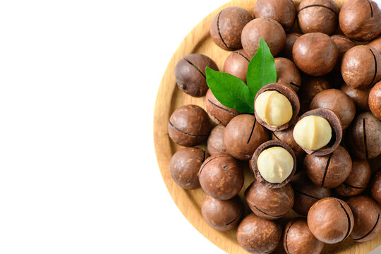 Macadamia Nuts with Kernels on Wooden Plate Isolated on White Background