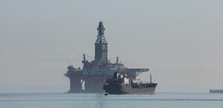 Walvis Bay, Namibia - May 26, 2025: Oil rig and tanker operating in Walvis Bay Namibia during calm waters