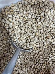 Pinto beans being scooped from a large pile as a nutritious culinary food background © dvoevnore