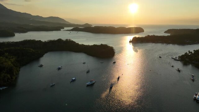Golden sunset over Puerto Galera bay with boats scattered across calm water