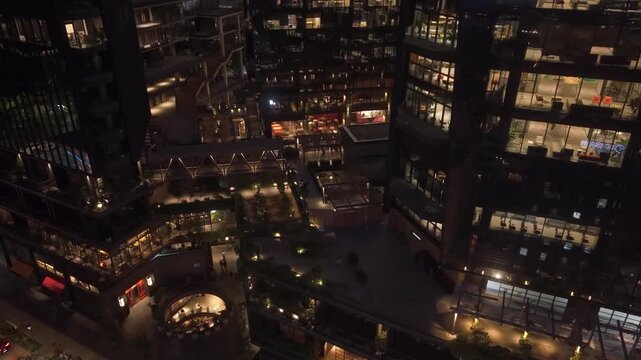 Aerial view ascending the illuminated shops and modern design of the Tobalaba Urban Market in the upscale business and residential district of Santiago, Chile, at night