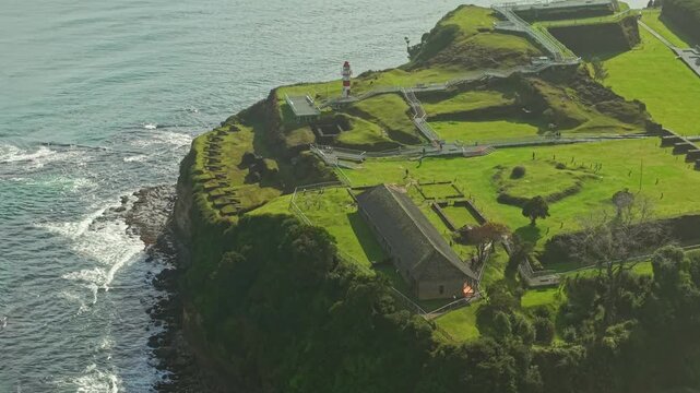 Flyover establishing of Fort Niebla, with a line of cannons and the Castellano house, with a modern walkway for visitors to explore, Valdivia, Chile