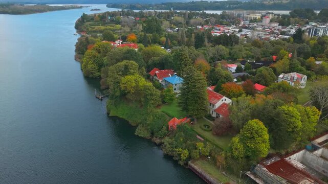 Aerial orbit panoramic view of the vegetation and architecture of Teja Island in Valdivia, Chile, with the Calle Calle River