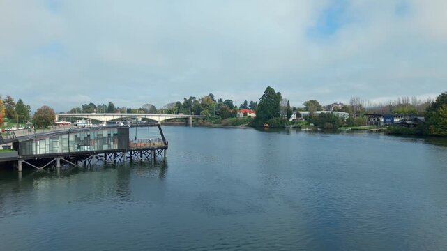 Aerial orbit over the Calle Calle River in Valdivia, Chile, featuring overlooks along its banks and the Pedro de Valdivia Bridge