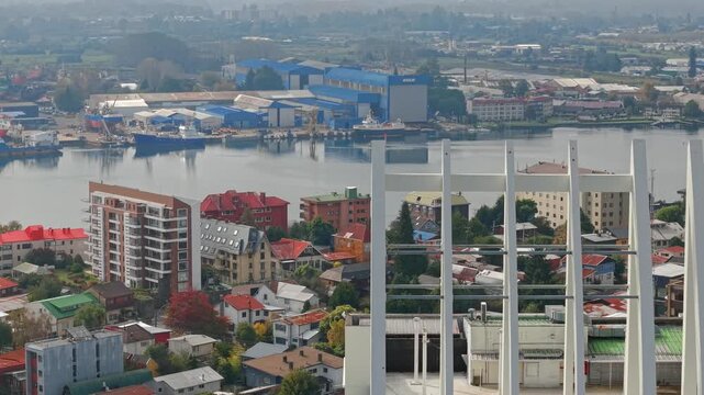 A telephoto aerial view of the architecture of Valdivia, Chile, showing ships under repair in the Calle Calle River on a sunny day